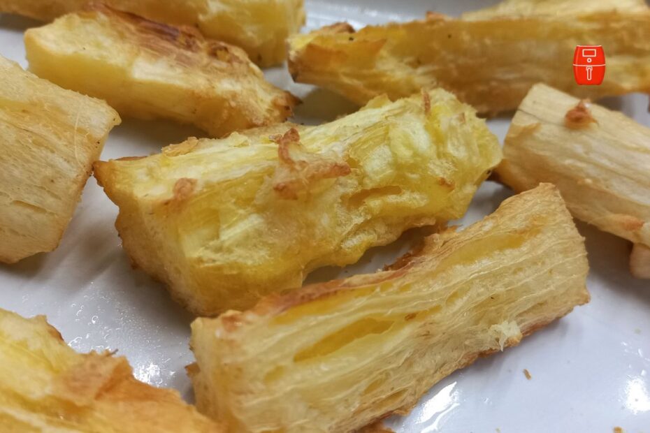 Mandioca frita na airfryer dourada e crocante por fora, com interior macio, servida em pedaços