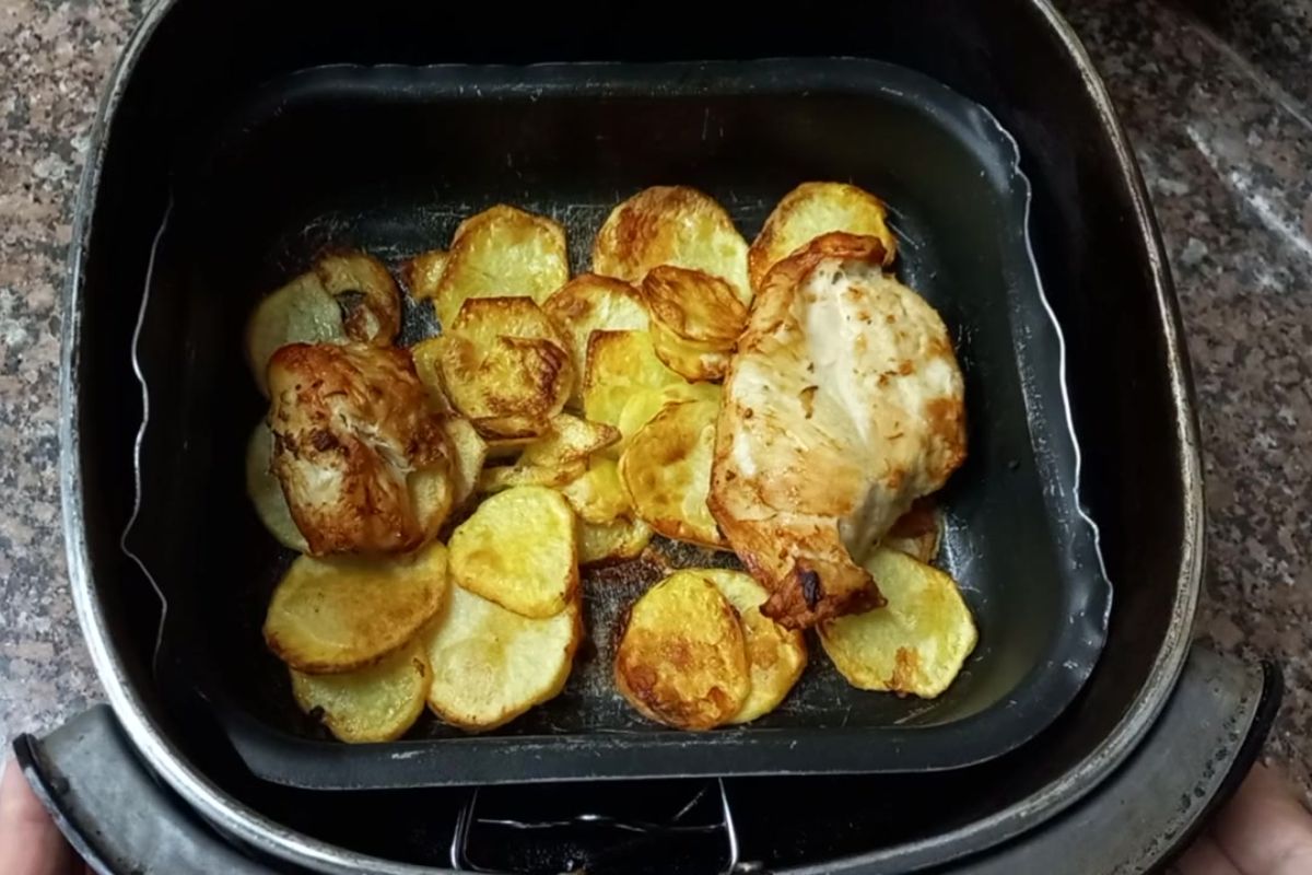 Peito de frango e batatas douradas na airfryer após o preparo